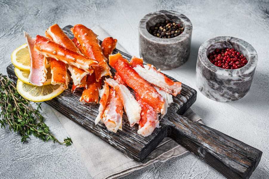 golden king crab legs on wooden cutting board