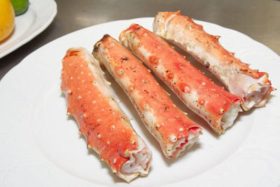 golden king crab legs on white plate