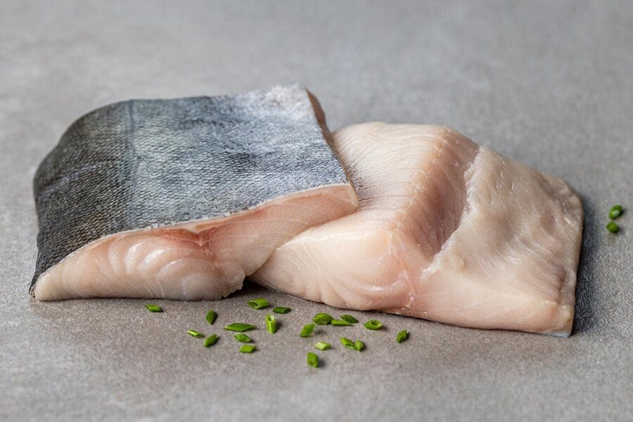 two raw wild alaska black cod portions with skin on
