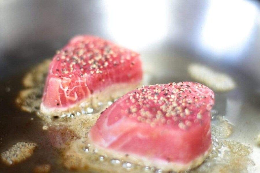 yellowfin tuna saku searing in pan with sesame seeds