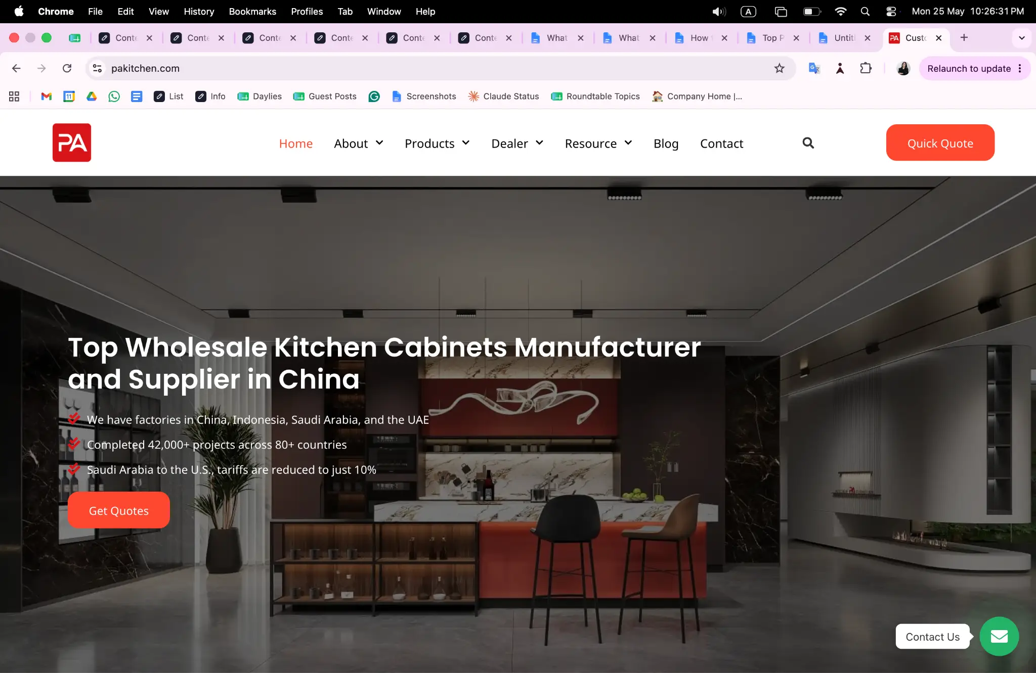 Modern kitchen interior with marble countertops, red cabinets, and high stools in sleek showroom setting