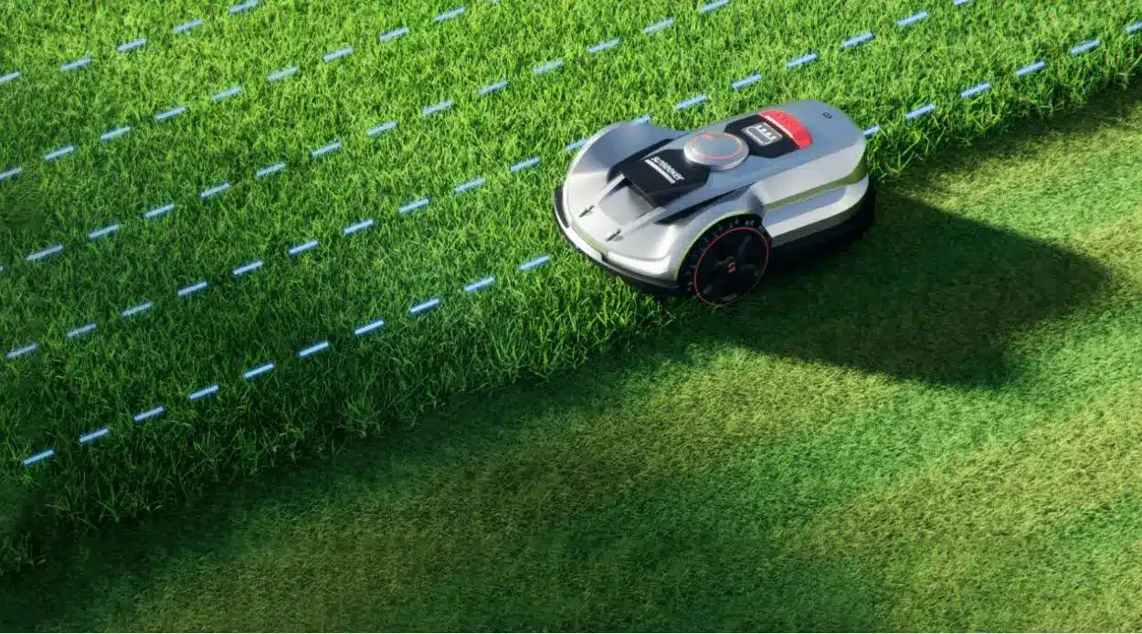 Robotic lawn mower cutting grass on a sunny lawn with precise straight lines