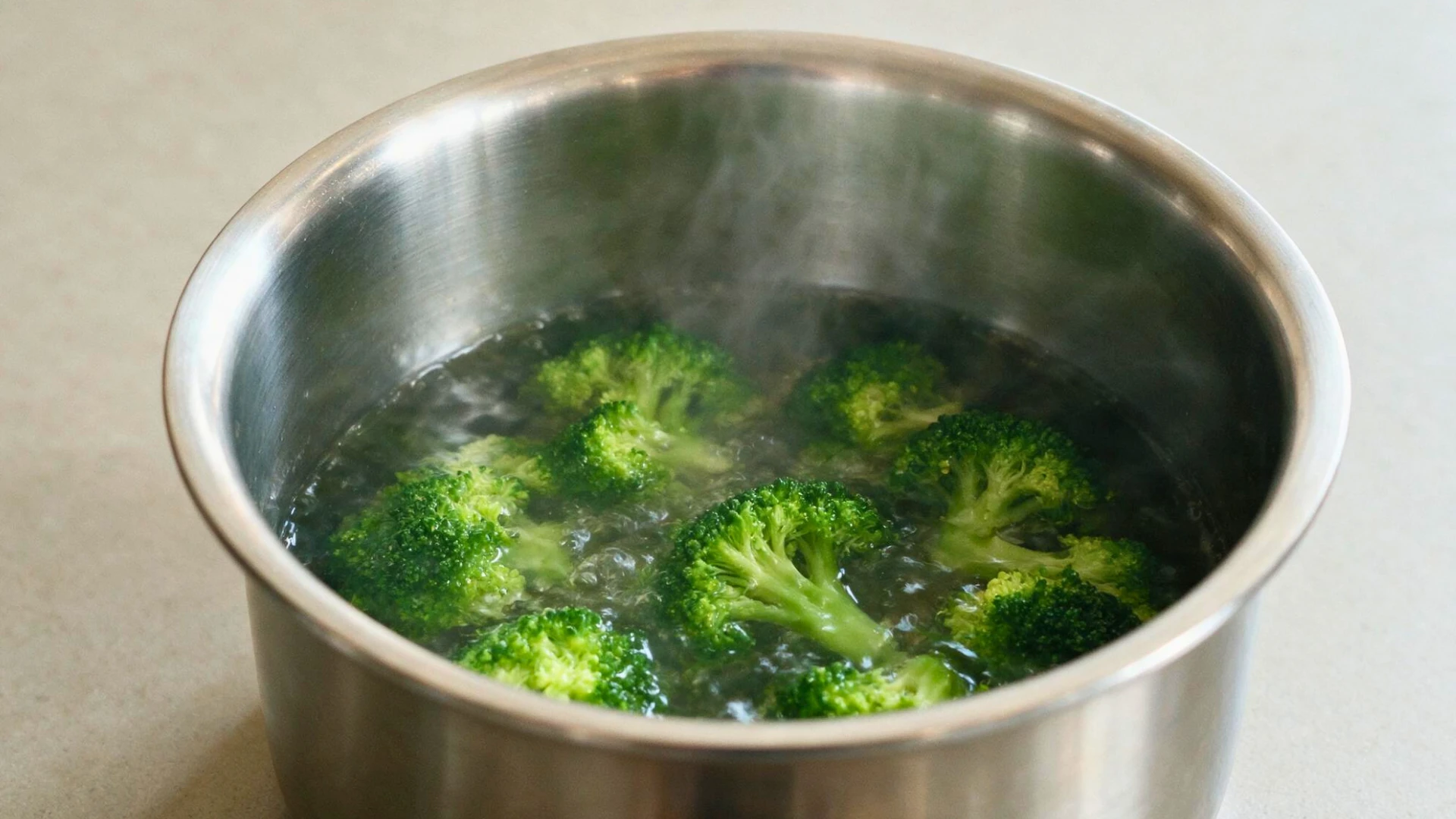 A pot containing water and vibrant green boiled broccoli.
