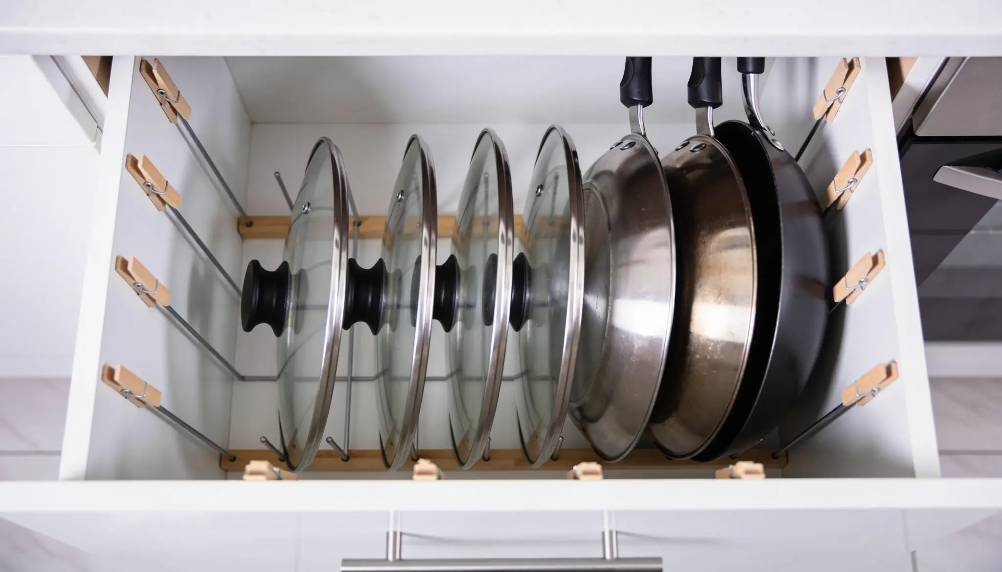 A kitchen drawer filled with various pots and pans, showcasing their different sizes and materials.