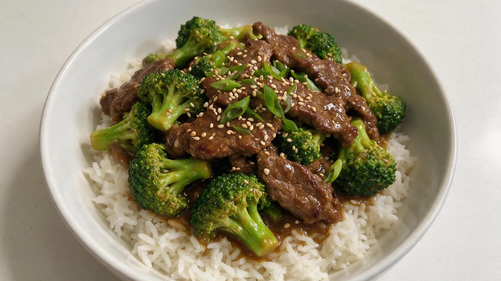 A serving of rice garnished with sautéed beef and fresh broccoli, showcasing a colorful and appetizing dish.